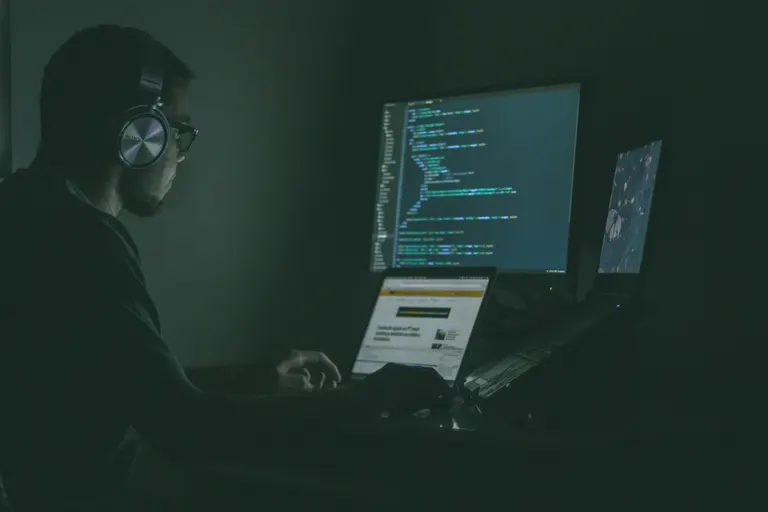 Technician working on a laptop in a dark workshop — computer and laptop repair by Chama Solution