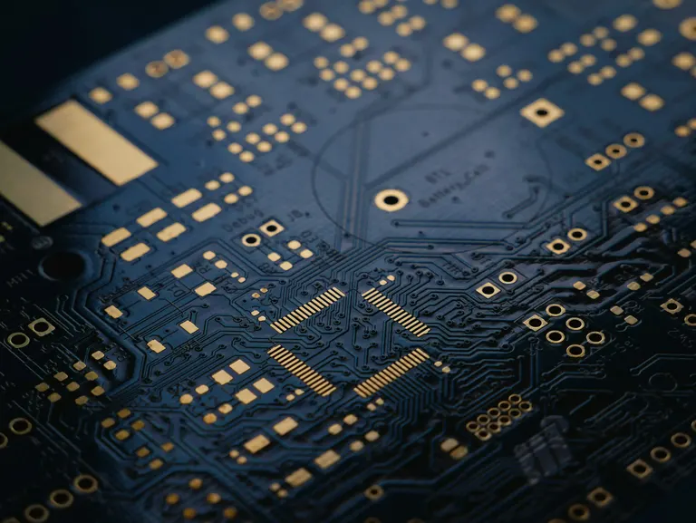 Close-up of a dark blue printed circuit board — computer repair and IT services by Chama Solution