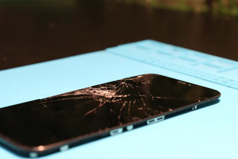 Smartphone with a cracked screen awaiting repair — phone screen replacement by Chama Solution